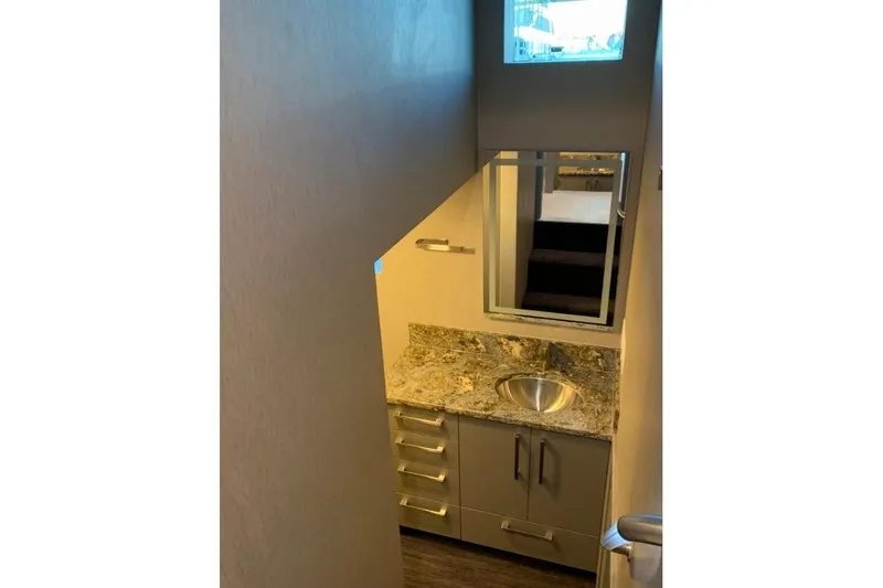 Slide: The Image of Compact bathroom with granite countertop, stainless steel sink, and mirror in Adonia Harmony Trip 2020. - 19