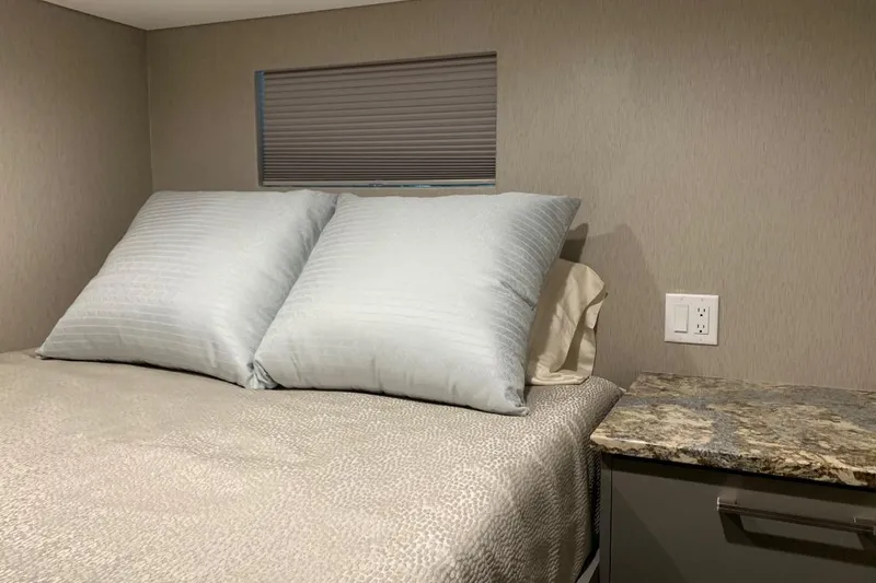 Slide: The Image of Cozy bedroom in Adonia Harmony Trip 2020 RV with plush pillows and granite nightstand. - 21