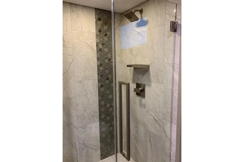 Slide: The Image of Modern shower with glass door, hexagonal tile accent, and sleek fixtures in Adonia Harmony Trip 2020. - 22
