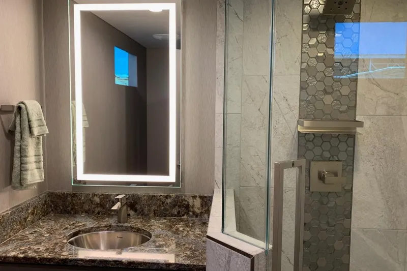 Slide: The Image of Modern bathroom with illuminated mirror, granite countertop, and hexagonal tile shower. Adonia Harmony Trip 2020. - 24