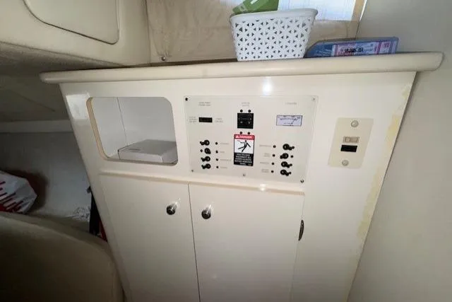 Slide: The Image of 2001 Bayliner 2855 Ciera cabin interior with control panel and storage. - 13