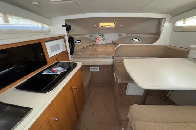Slide: The Image of 2001 Bayliner 2855 Ciera cabin interior with kitchenette, dining area, and sleeping quarters. - 6