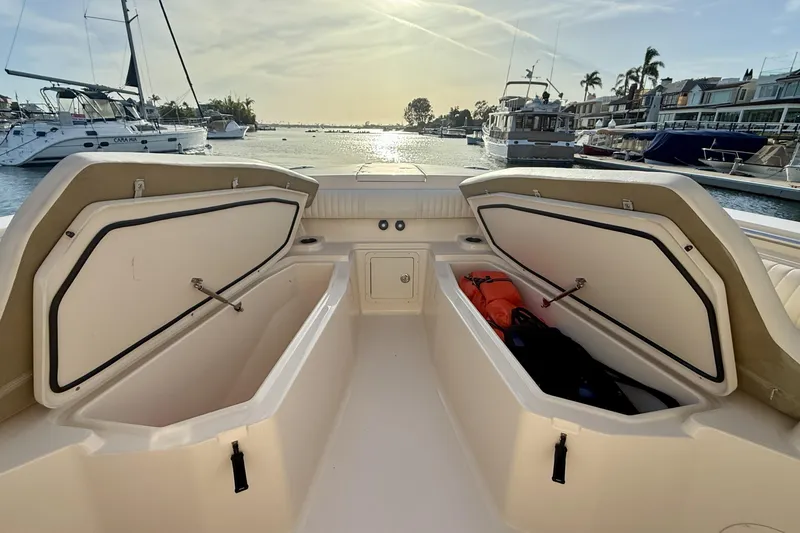 Slide: The Image of 2012 Grady-White Canyon 336 boat with open storage compartments, docked in a marina. - 12
