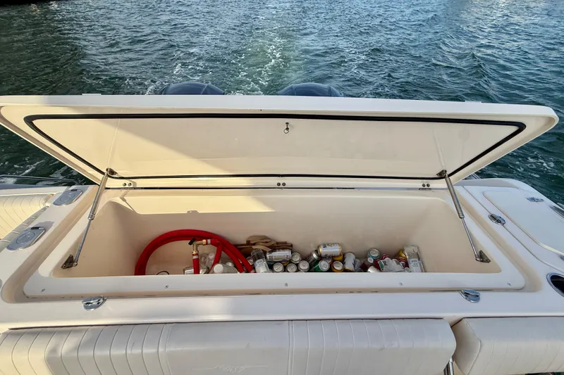 Slide: The Image of Open storage compartment on 2012 Grady-White Canyon 336 boat, filled with drinks and supplies. - 15