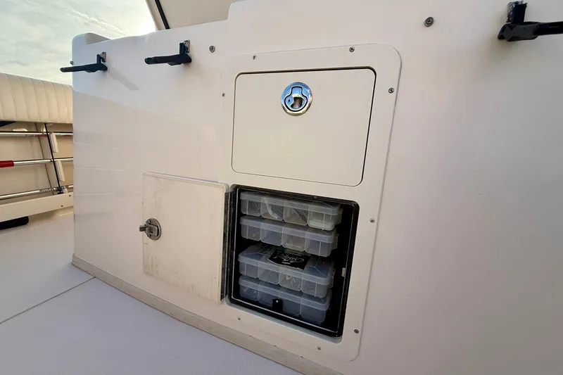 Slide: The Image of Storage compartment on a 2012 Grady-White Canyon 336 boat, featuring organized tackle boxes. - 20