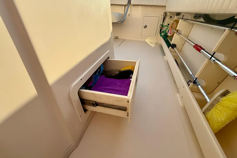 Slide: The Image of Storage drawer on 2012 Grady-White Canyon 336 boat, containing cleaning supplies and brushes. - 22