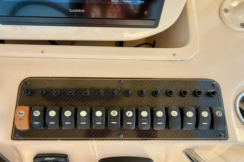 Slide: The Image of Control panel of a 2012 Grady-White Canyon 336 boat with labeled switches. - 37