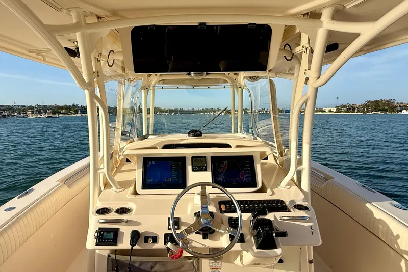 Slide: The Image of 2012 Grady-White Canyon 336 boat helm with dual displays, steering wheel, and ocean view. - 43