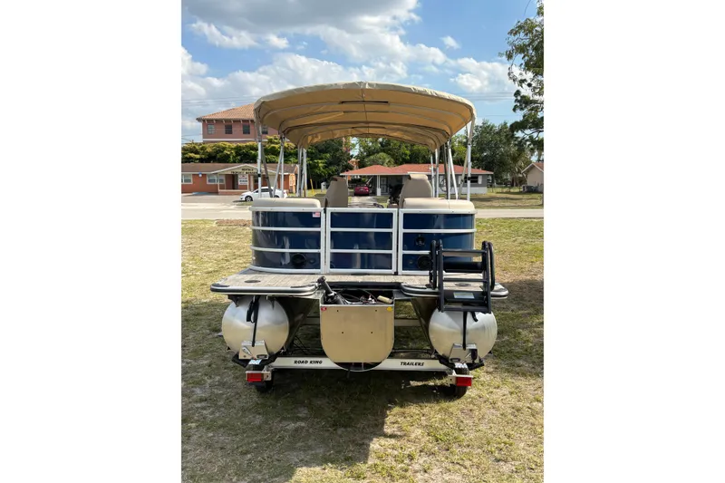 Slide: The Image of 2026 Bentley Pontoons Legacy 223 Navigator on trailer, blue hull, beige canopy. - 6