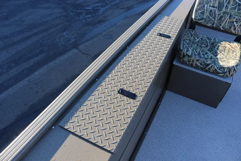 Slide: The Image of 2026 Smoker Craft Pro Sportsman 1866 boat interior with camo seating and diamond plate storage. - 12