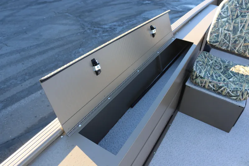 Slide: The Image of Open storage compartment on 2026 Smoker Craft Pro Sportsman 1866 boat with camo seating. - 13