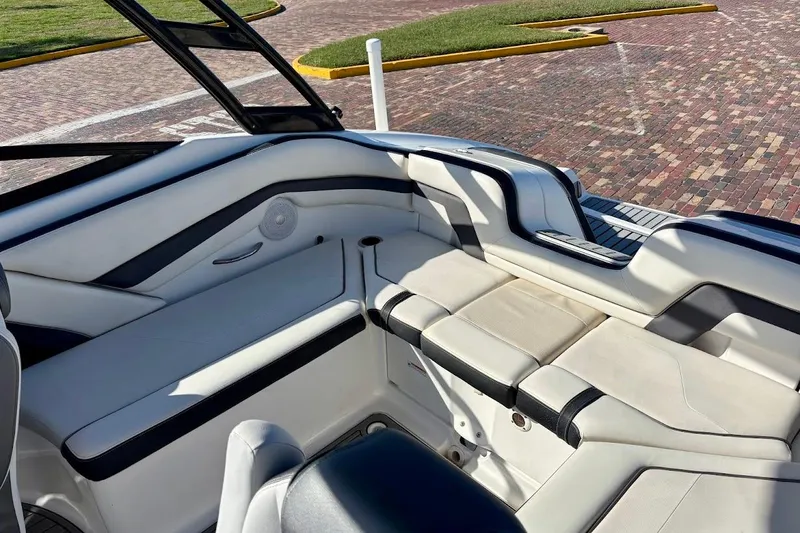 Slide: The Image of 2016 Yamaha Boats AR240 HO interior with white and black seating, dockside view. - 18