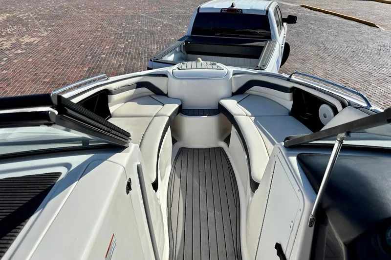 Slide: The Image of 2016 Yamaha Boats AR240 HO interior with seating and a pickup truck in the background. - 27