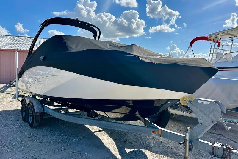 Slide: The Image of 2016 Yamaha Boats AR240 HO covered on trailer under a blue sky. - 33