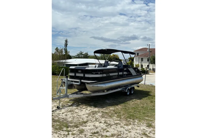 Slide: The Image of 2026 Bentley Pontoons Elite 253 Swingback on trailer, parked outdoors. - 13