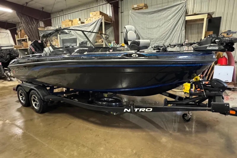The Image of 2026 Nitro ZV19 Sport Pro boat in a garage, on a trailer, with visible equipment. - 0