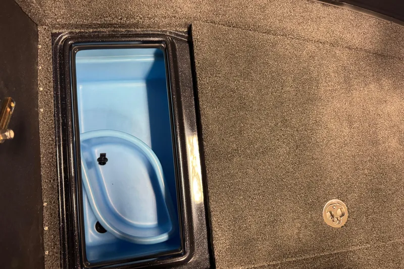 Slide: The Image of Livewell compartment in 2026 Nitro ZV19 Sport Pro boat, featuring blue interior and carpeted surface. - 14