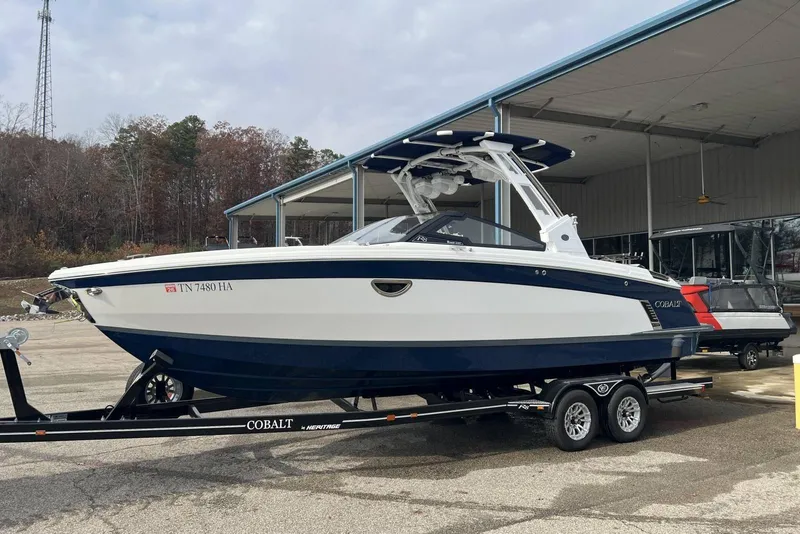 The Image of 2022 Cobalt R8 Surf boat on trailer, parked outdoors near a covered area. - 11