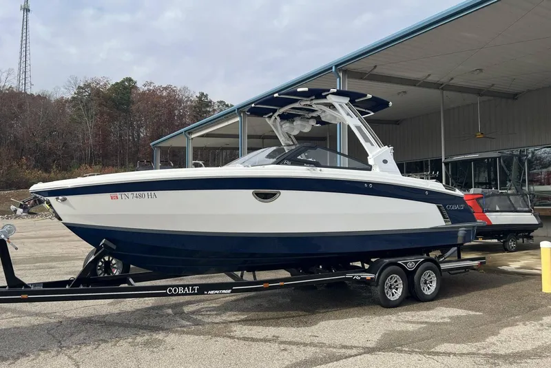 Slide: The Image of 2022 Cobalt R8 Surf boat on trailer, parked outdoors near a building. - 15
