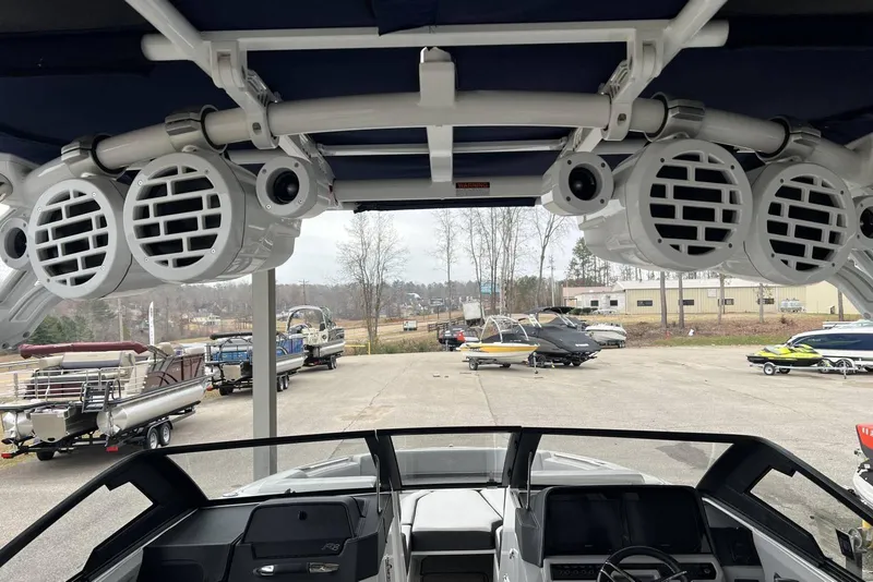 Slide: The Image of 2022 Cobalt R8 Surf boat interior with speakers, parked in a marina. - 22