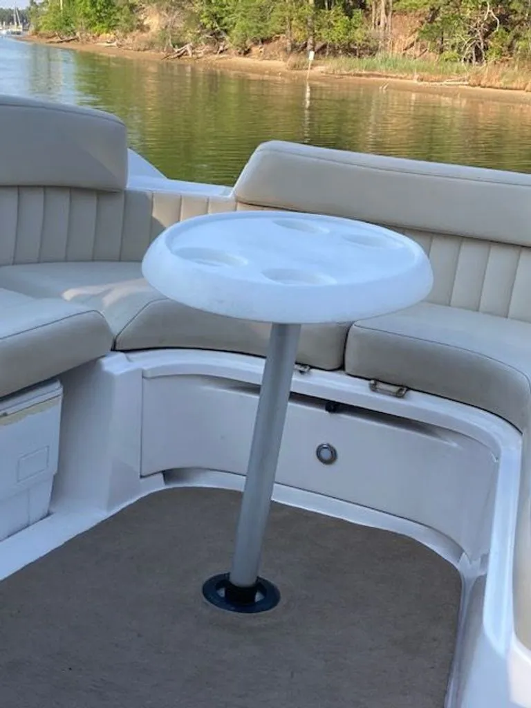 Slide: The Image of Interior of a 2009 Regal 2450 Cuddy boat with table and seating area. - 16