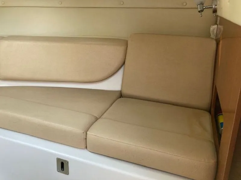 Slide: The Image of Interior of 2009 Regal 2450 Cuddy with beige cushioned seating. - 25
