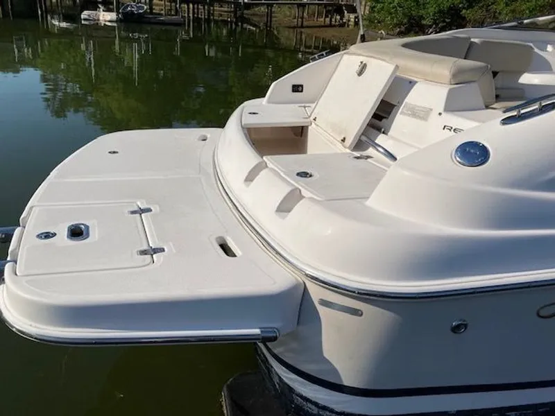 Slide: The Image of 2009 Regal 2450 Cuddy boat by the water with swim platform. - 33