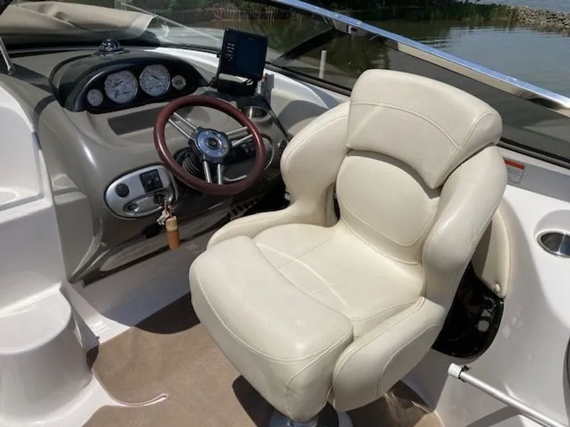 Slide: The Image of Interior of a 2009 Regal 2450 Cuddy boat with steering wheel and seat. - 8
