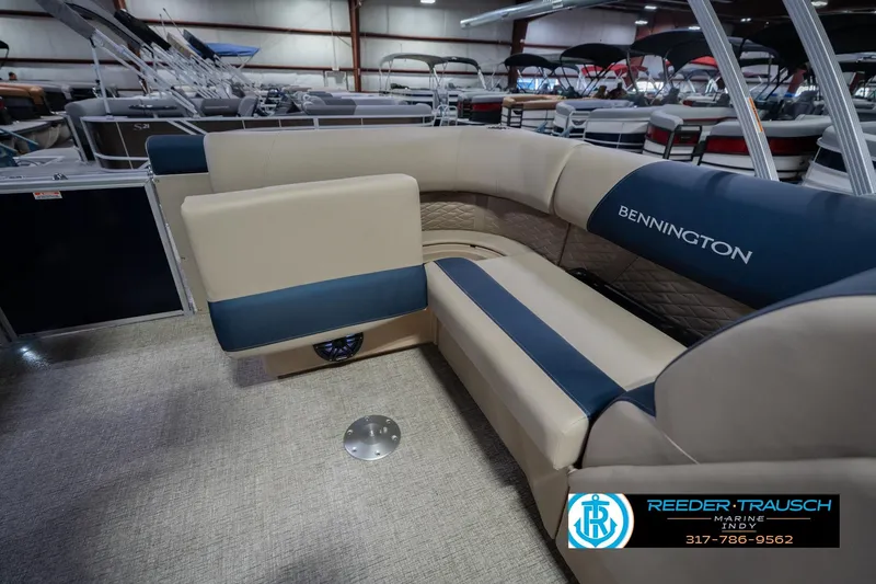 Slide: The Image of 2026 Bennington 21 SLJ pontoon boat interior with beige and blue seating in showroom. - 26