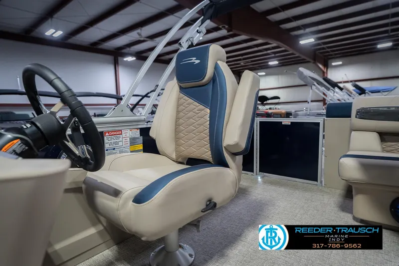 Slide: The Image of 2026 Bennington 21 SLJ boat interior with luxurious seating and steering wheel in showroom. - 36