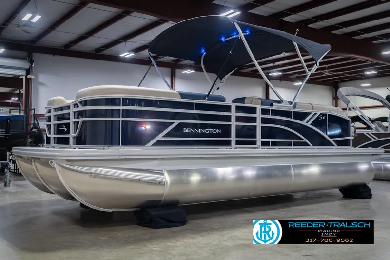 Slide: The Image of 2026 Bennington 21 SLJ pontoon boat in showroom with canopy and sleek design. - 4