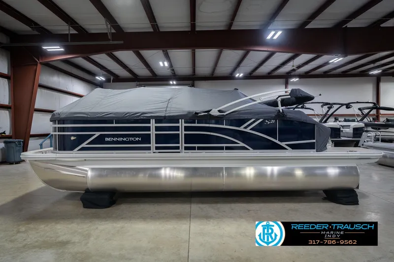 Slide: The Image of 2026 Bennington 21 SLJ pontoon boat in indoor showroom, covered and ready for sale. - 54