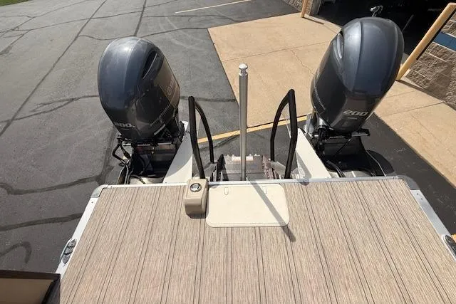 Slide: The Image of 2021 Premier 250 Grand Majestic RF boat with dual outboard motors on a wooden deck. - 22
