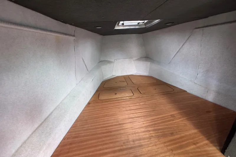 Slide: The Image of Interior cabin of a 2003 ACB 30 boat, featuring wooden flooring and white walls. - 10