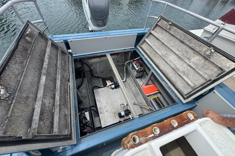 Slide: The Image of Open engine compartment of a 2003 ACB 30 boat, showing batteries and equipment. - 12