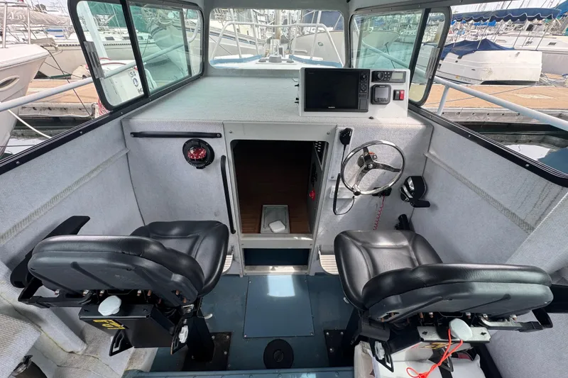 Slide: The Image of Interior of a 2003 ACB 30 boat with dual black seats and navigation equipment. - 7