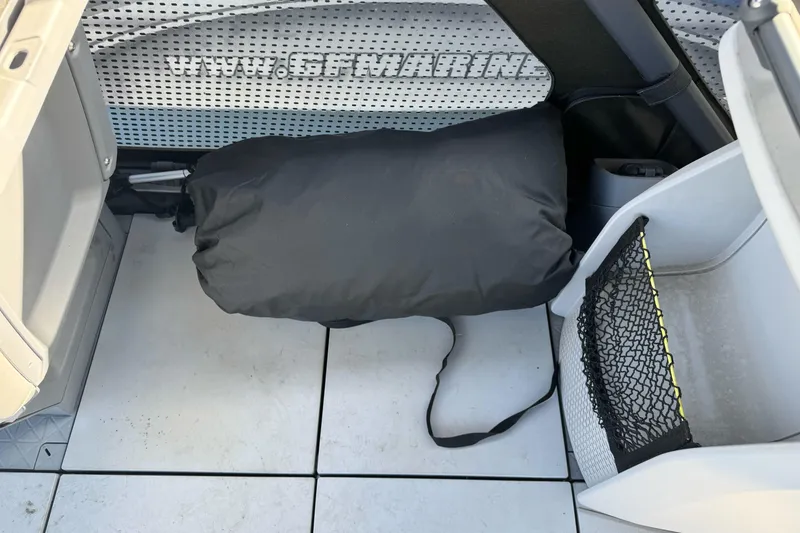 Slide: The Image of 2023 Sea-Doo Switch Cruise 21 interior storage area with black bag and netting. - 14