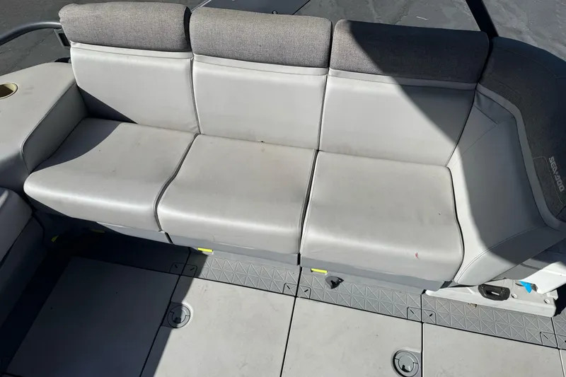 Slide: The Image of 2023 Sea-Doo Switch Cruise 21 boat seating, featuring gray cushioned seats and deck flooring. - 18