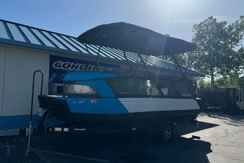 Slide: The Image of 2023 Sea-Doo Switch Cruise 21 pontoon boat parked outside a building. - 2
