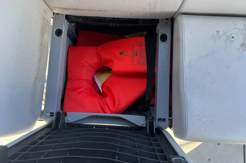 Slide: The Image of Storage compartment with red life jacket on 2023 Sea-Doo Switch Cruise 21 boat. - 23