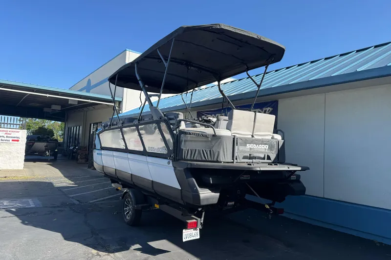 Slide: The Image of 2023 Sea-Doo Switch Cruise 21 pontoon boat parked outside a building. - 4