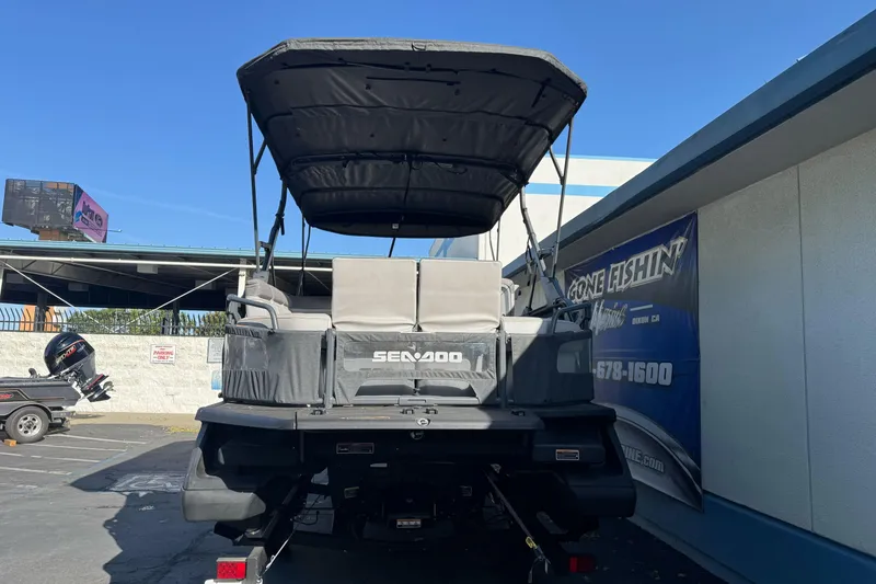 Slide: The Image of 2023 Sea-Doo Switch Cruise 21 pontoon boat parked outdoors, rear view. - 5