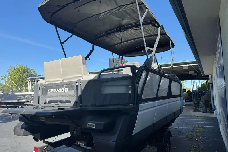 Slide: The Image of 2023 Sea-Doo Switch Cruise 21 pontoon boat with canopy, parked outdoors. - 6