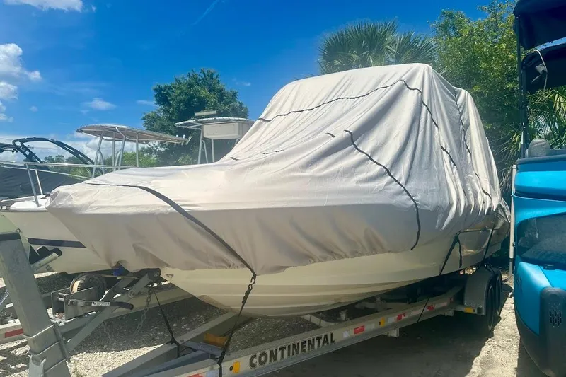 Slide: The Image of Covered 2004 Sea Ray 270 Sundeck boat on trailer, parked outdoors under blue sky. - 47