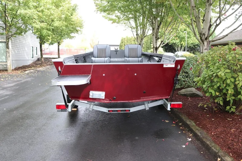 Slide: The Image of 2026 Alumaweld Free Drifter 18 boat, rear view, parked on a tree-lined street. - 16