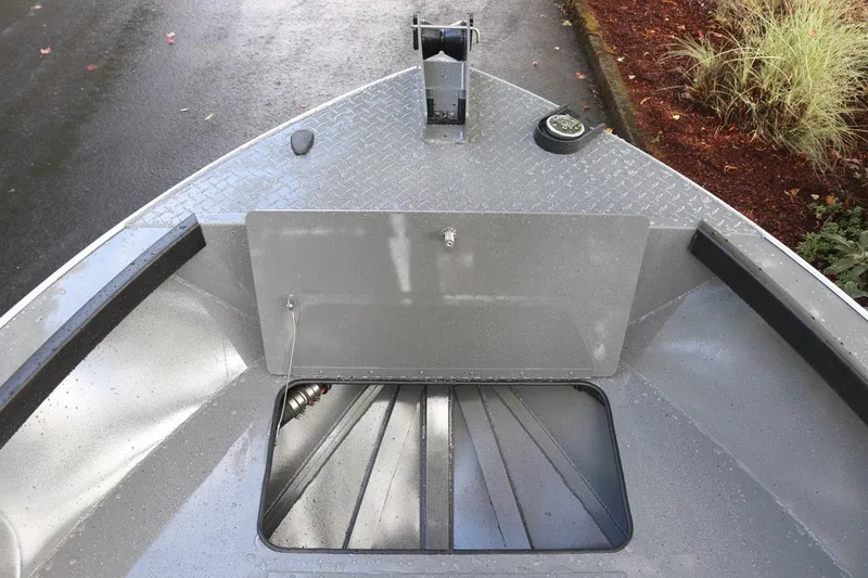 Slide: The Image of 2026 Alumaweld Free Drifter 18 boat interior, featuring a storage compartment and diamond plate flooring. - 7