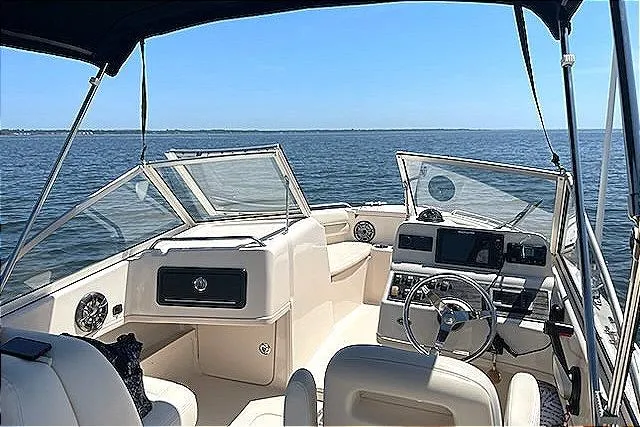 Slide: The Image of 2020 Grady-White Freedom 192 boat interior with steering wheel, dashboard, and open water view. - 6