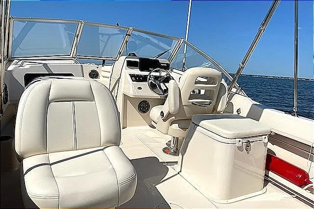 Slide: The Image of 2020 Grady-White Freedom 192 boat interior with plush seating and steering console on open water. - 7