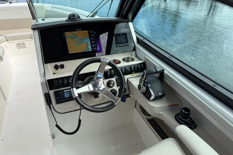 Slide: The Image of 2023 Boston Whaler 280 Vantage helm with navigation display and controls. - 3