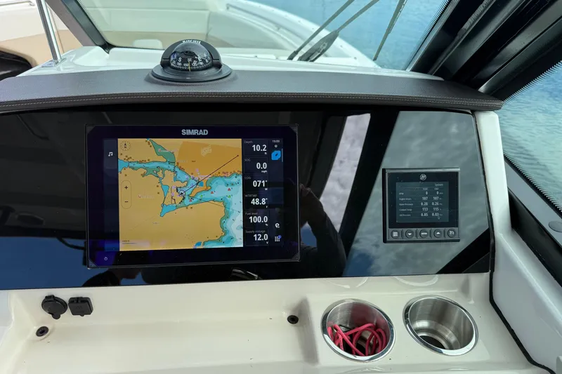 Slide: The Image of 2023 Boston Whaler 280 Vantage dashboard with Simrad navigation display and compass. - 4